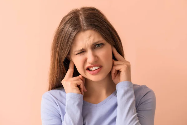 Mujer Joven Que Sufre Ruido Fuerte Fondo Color —  Fotos de Stock