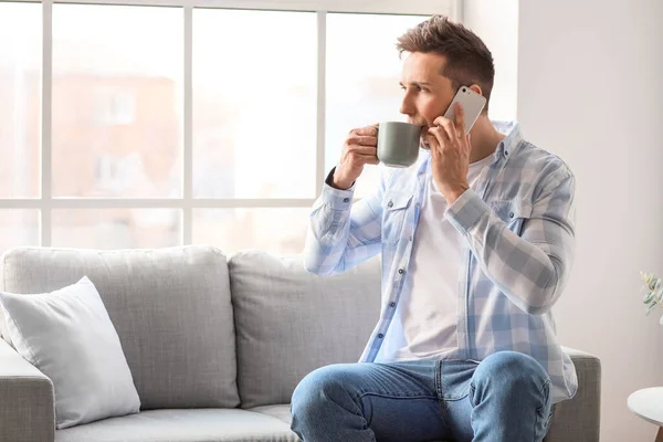 Evde Telefonla Konuşurken Kahve Içen Yakışıklı Adam — Stok fotoğraf
