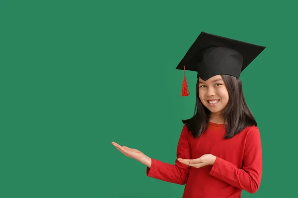 色の背景に何かを示す卒業帽子の女の子 — ストック写真