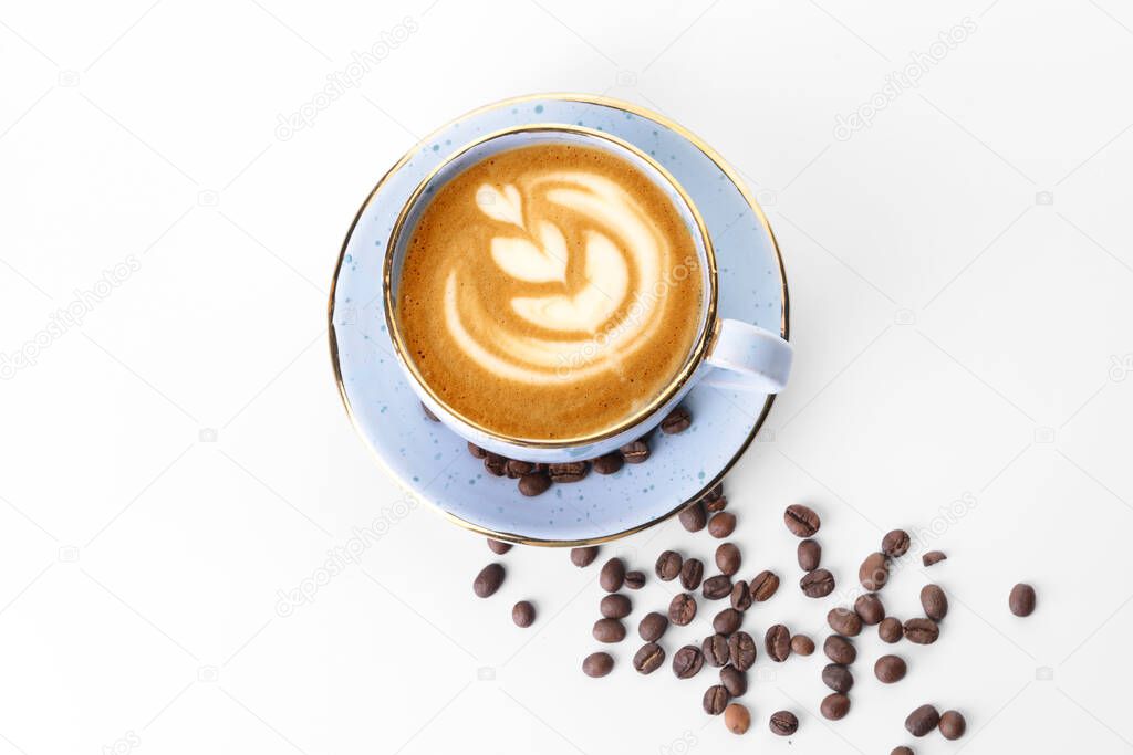 Cup of tasty cappuccino and coffee beans on white background