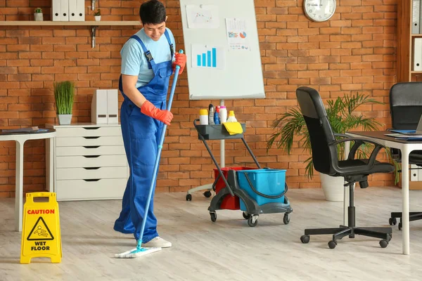 オフィスの男性清掃員のモッピングフロア — ストック写真