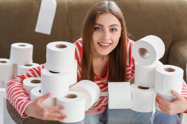 Evinde tuvalet kağıdı yığını olan bir kadın. Koronavirüs salgını kavramı