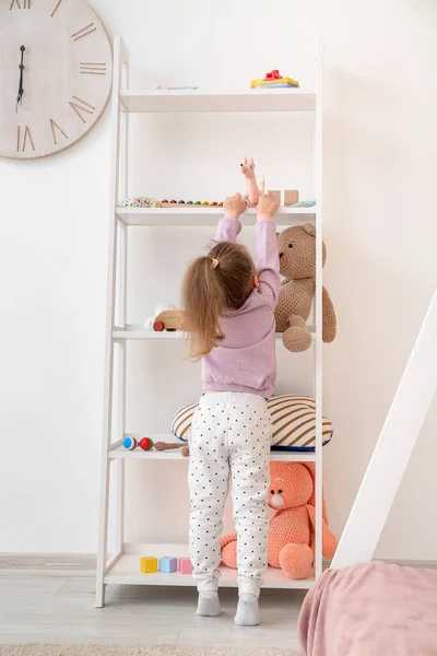 Маленька Дівчинка Біля Стійки Іграшками Вдома — стокове фото