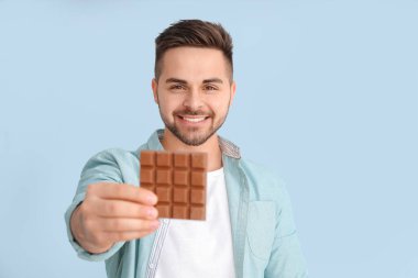 Renkli çikolatası olan yakışıklı bir genç.