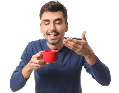 Beyaz arka planda bir fincan sıcak kahveyle genç bir adam.
