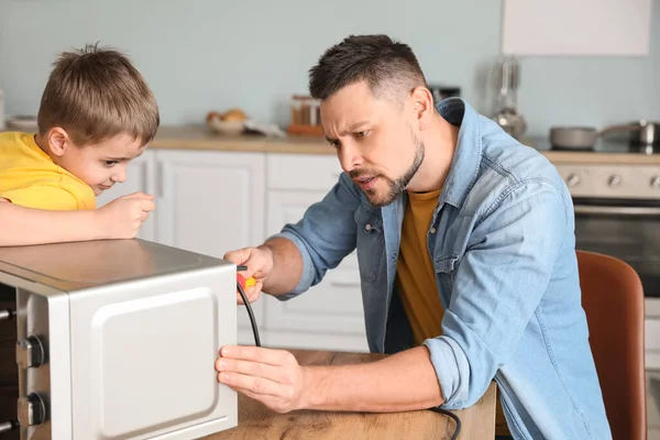 Little Son Helping His Father Repair Microwave Oven Kitchen — Stock Photo, Image