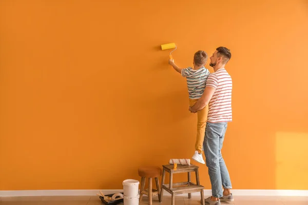 Pequeno Filho Ajudando Seu Pai Pintar Parede Casa — Fotografia de Stock