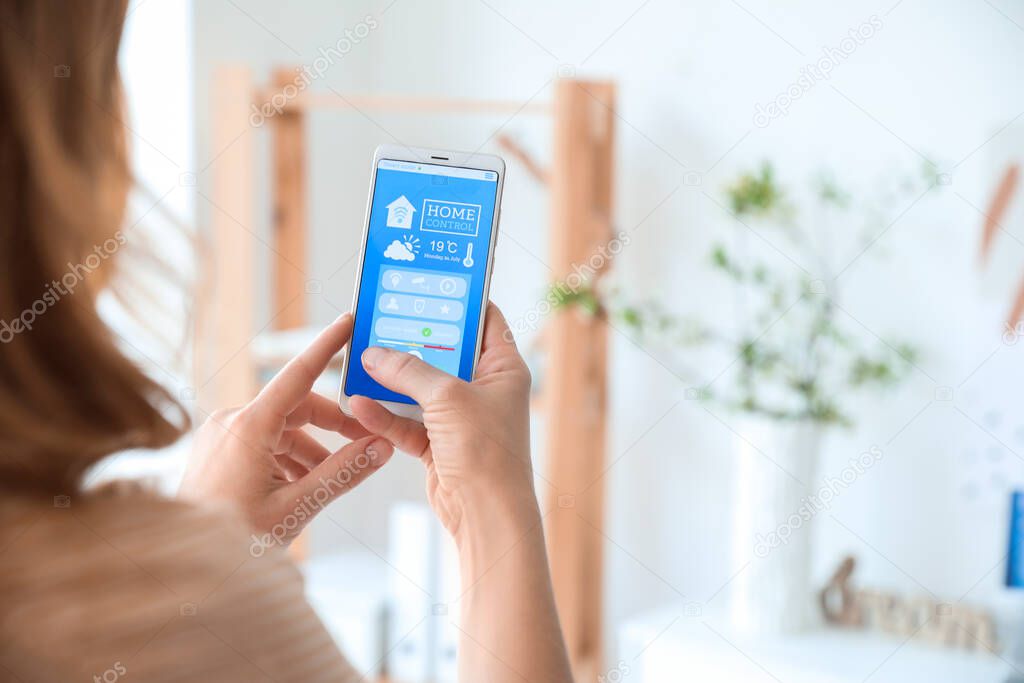 Woman using application of smart home automation