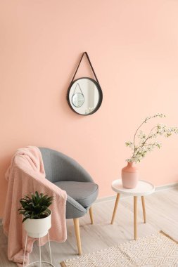 Şık aynalı ve çiçek açan ağaç dalları olan oturma odasının içinde.