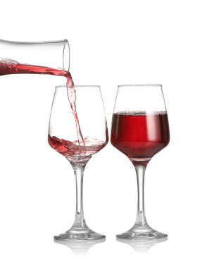 Şarap sürahisinden beyaz arka planda cama dökülüyor