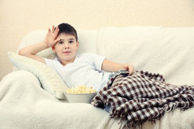 Çocuk evde televizyon izliyor.