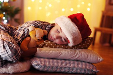 Küçük çocuk şöminenin yanında uyuyor.