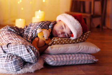 Küçük çocuk şöminenin yanında uyuyor.