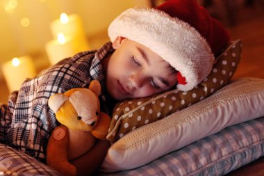 Küçük çocuk şöminenin yanında uyuyor.