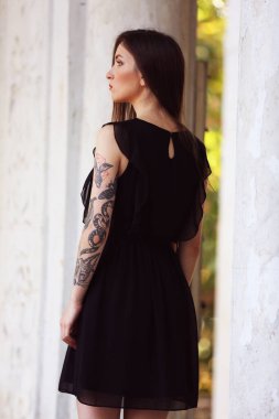 Dışarıda, sütunların arasında genç bir kadın