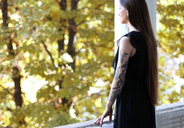 Dışarıda, sütunların arasında genç bir kadın