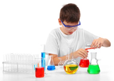 Zeki küçük çocuk beyaz üzerinde izole edilmiş kimyasal deneyler yapıyor.