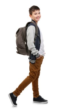 Gri sırt çantalı şirin küçük çocuk sağa gidiyor, beyaz üzerinde izole edilmiş.