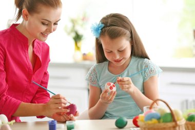 Anne ve kızı Paskalya arifesinde yumurta boyuyor.