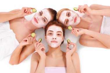 Yüz maskeleriyle rahatlayan genç ve güzel kadınlar.