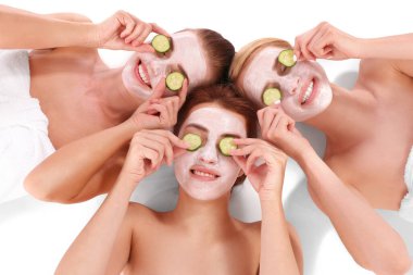 Yüz maskeleriyle rahatlayan genç ve güzel kadınlar.
