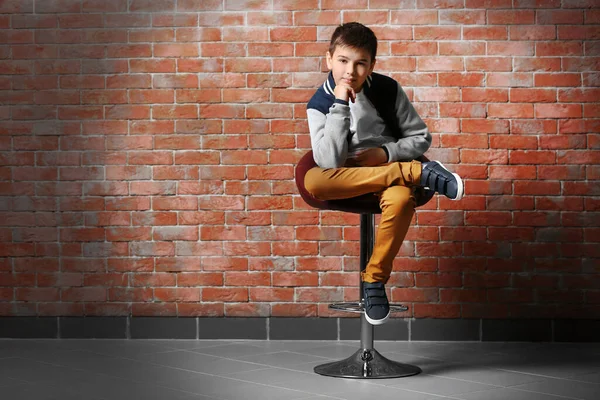 Mignon Petit Garçon Assis Sur Une Chaise Près Mur Briques — Photo