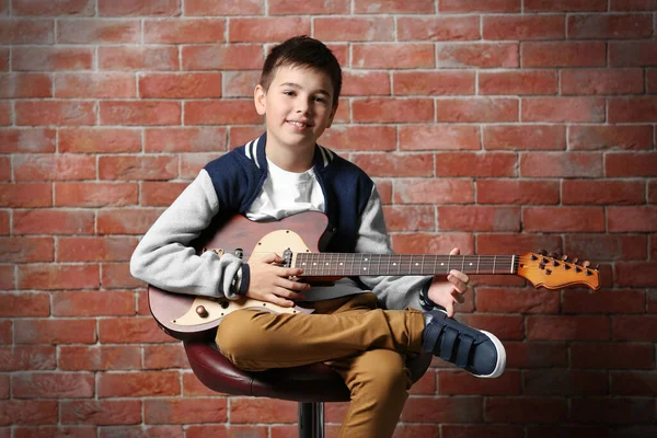 Tuğla Duvar Arkasında Gitar Çalan Sevimli Bir Çocuk — Stok fotoğraf