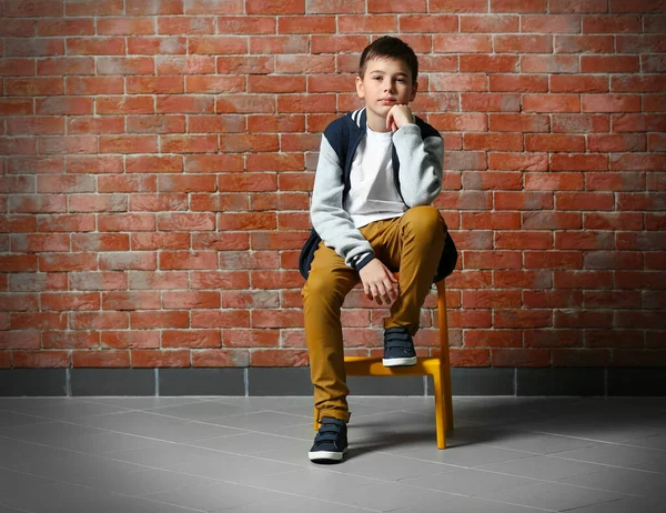 Mignon Petit Garçon Assis Sur Une Chaise Près Mur Briques — Photo
