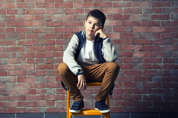 Lindo Niño Sentado Una Silla Cerca Pared Ladrillo —  Fotos de Stock