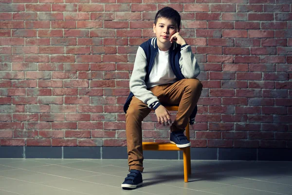 Lindo Niño Sentado Una Silla Cerca Pared Ladrillo —  Fotos de Stock