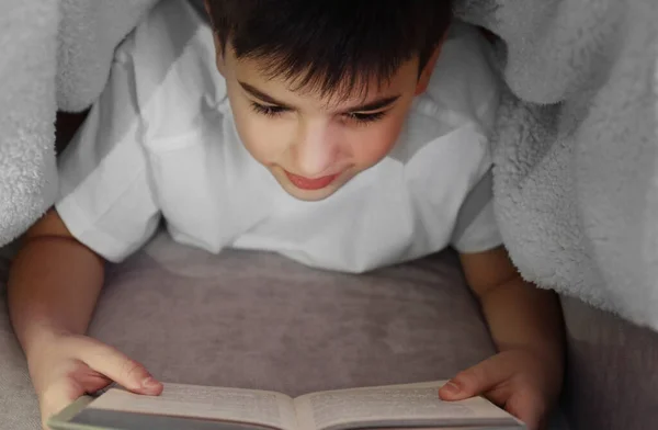 Μικρό Αγόρι Διαβάζει Βιβλίο Κάτω Από Την Κουβέρτα — Φωτογραφία Αρχείου