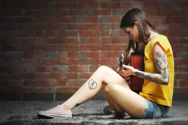 Aantrekkelijke Vrouw Met Tattoo Spelen Gitaar Baksteen Achtergrond — Stockfoto
