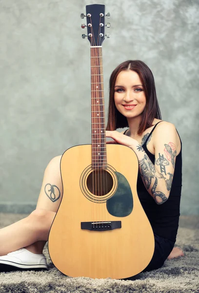 Vrouw Met Tatoeage Gitaar Zittend Grijze Achtergrond — Stockfoto