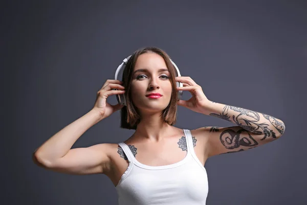 Hermosa Mujer Joven Con Tatuaje Usando Auriculares Posando Sobre Fondo — Foto de Stock