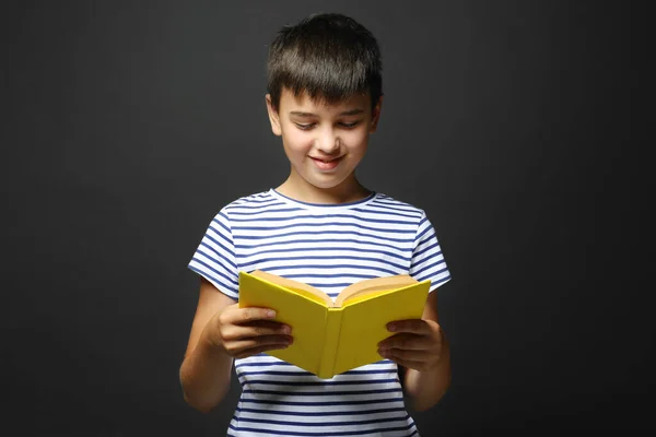 Netter Junge Liest Buch Auf Grauem Hintergrund — Stockfoto