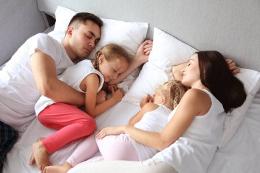Yatakta uyuyan sevimli bir aile.