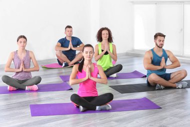 Yoga ve meditasyon yapan bir grup insan.