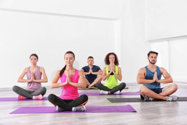 Yoga ve meditasyon yapan bir grup insan.
