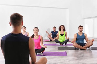 Yoga ve meditasyon yapan bir grup insan.