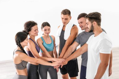 Takım çalışması konsepti. Spor salonunda bir grup insan el ele tutuşuyor.