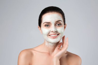 Güzel genç bir kadın yüzüne maske takıyor, yakın plan.
