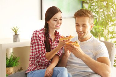 Evde pizza yiyen genç bir çift.