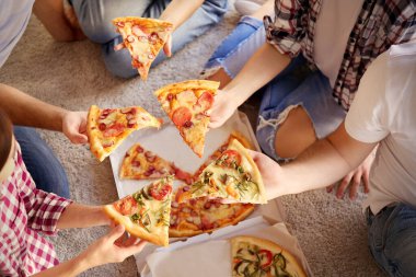 Arkadaşlar eğleniyor ve pizza yiyorlar.