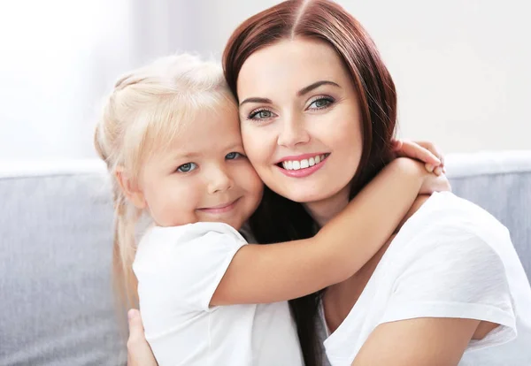 Happy mother with daughter on couch