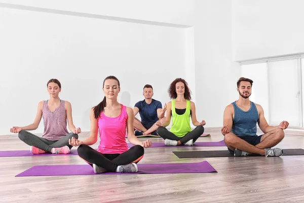 Yoga ve meditasyon yapan bir grup insan.