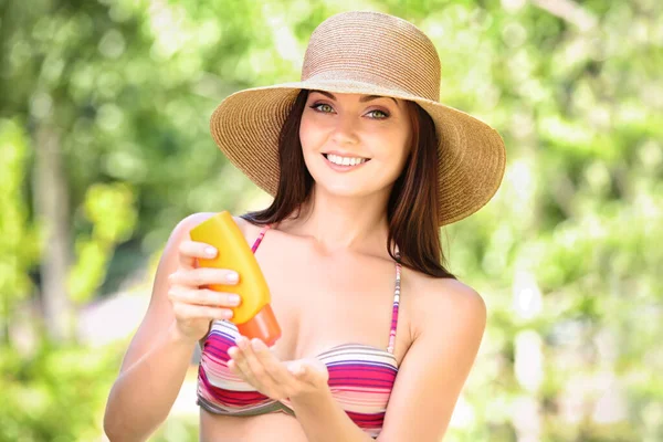 Jonge Vrouw Hoed Badpak Van Toepassing Zonnebrandcrème Wazig Natuur Achtergrond — Stockfoto