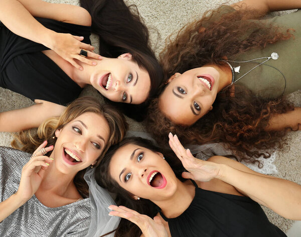 Beautiful girls lying on floor, top view