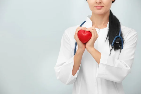 Doctora Con Estetoscopio Sosteniendo Corazón Sobre Fondo Claro —  Fotos de Stock