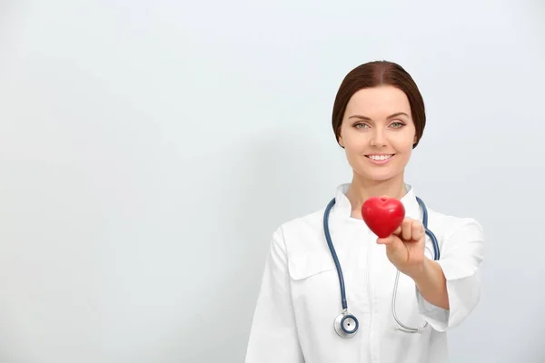 Ženský Lékař Stetoskopem Drží Srdce Světlém Pozadí — Stock fotografie