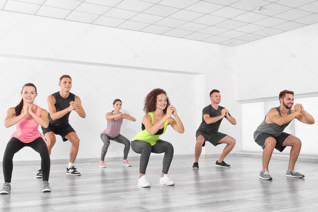 Group of people doing yoga exercises  in gym